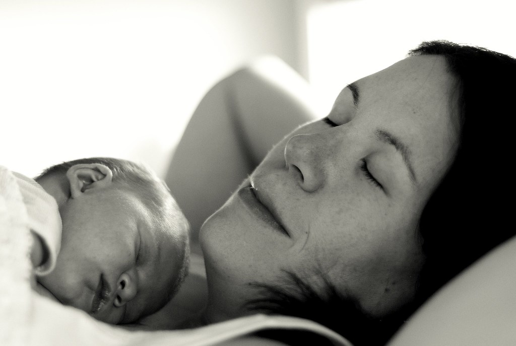 madre durmiendo con recién nacido