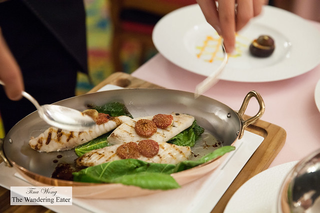 Our waiter plating grilled John Dory fillet with fig leaves, balsamic vinegar sauce, roasted figs with colorful bell peppers and eggplant fritter