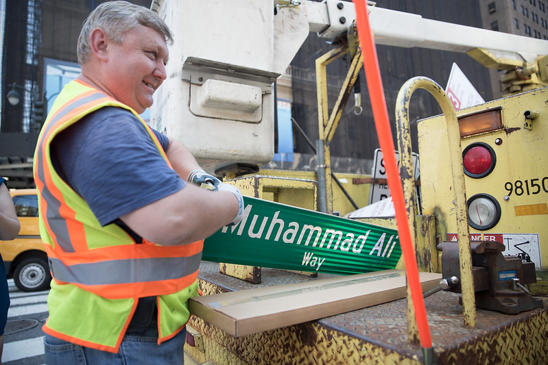 Department of Transportation employees install a street sign renaming West 33rd Street between Eighth and Seventh Avenues, "Muhammad Ali Way"