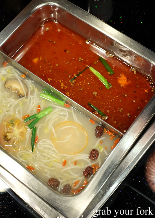 Chicken stock and spicy Sichuan stock for steamboat at Shancheng Hotpot King, Sydney