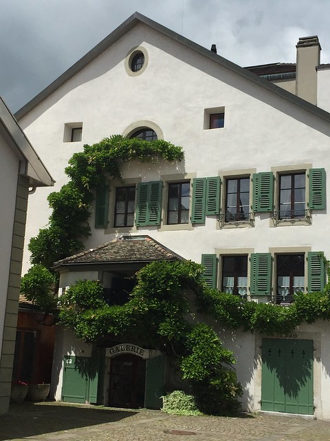 Nyon's main square: a typical local house with sloping roof, green wooden shutters and a climbing evergree.n. Nyon is the perfect kid-friendly trip from Geneva but also a pleasant stop without children
