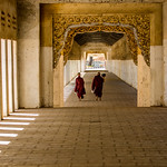 Two monks walking, not carrying the ricebowl like everyone does