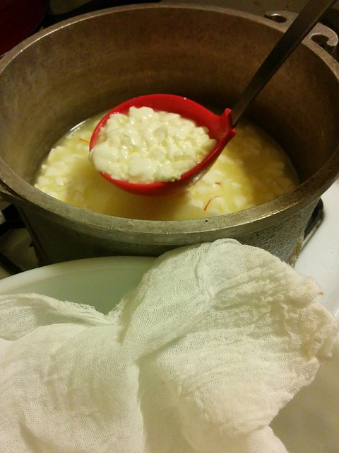 Ladling saffron curds into cheese cloth to strain out whey